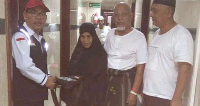 Petugas Kloter 19 saat menyerahkan tas paspor milik warga yang hilang kemarin.